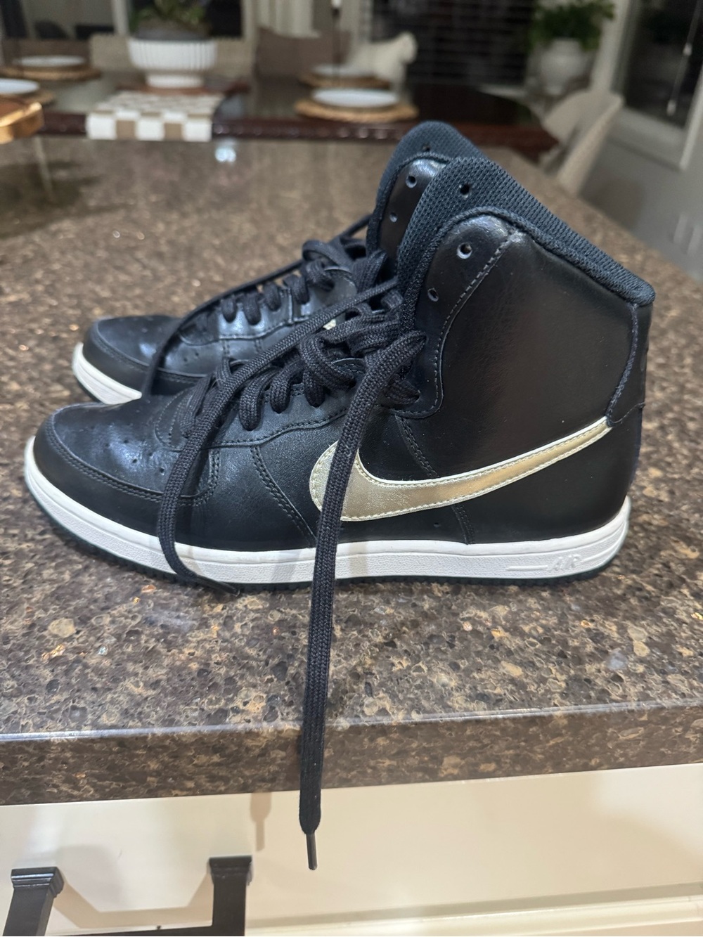 Woman’s Nike Black High-Top Sneakers with Gold Swoosh